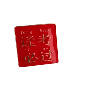 Square red and gold enamel lapel pin with feng kao bi guo character for good luck