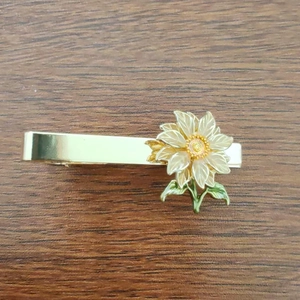 Eleganter goldener Sonnenblumen-Krawattenclip mit weißen Harzblättern auf dunklem Holz
