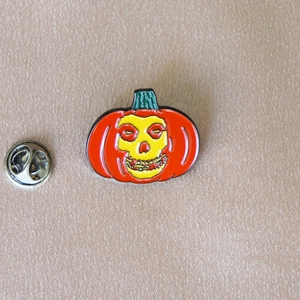 Halloween enamel pumpkin brooch with iconic skull design and silver butterfly clutch