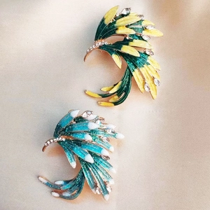 Detailed close-up of phoenix brooches with rhinestones on beige silk background