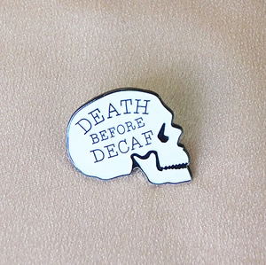 Halloween enamel pin with white skull design and Death Before Decaf text print