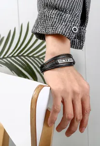 Detail of men's multilayer black leather bracelet with vintage metal buckle on wrist