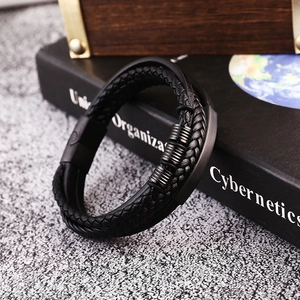 Detail of multi-layer braided leather bracelet with black magnetic clasp on a book