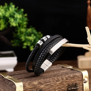 Macro shot of men's multi-layer black leather bracelet with silver stainless steel magnetic clasp