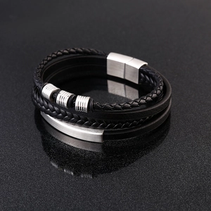 Detailed macro view of multi-layer black leather bracelet with brushed steel magnetic clasp