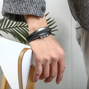 Close-up of a men's multi-layer black leather bracelet with silver metal buckle on wrist