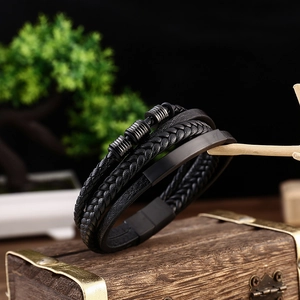 Close-up of multi-layer braided leather bracelet on a vintage chest with magnetic clasp