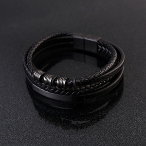 Macro detail of multi-layer braided leather bracelet with black textured metal accents