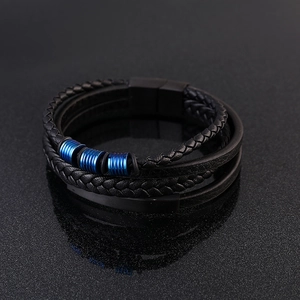 Detailed close-up of multi-layer black leather bracelet with blue metal rings and magnetic clasp