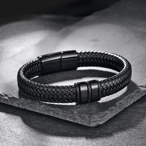 Men's minimalist black braided leather bracelet with magnetic metal clasp on rock