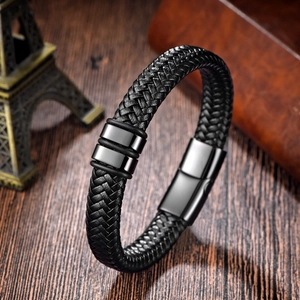 Men's braided black leather bracelet with magnetic metal clasp on a vintage wood background