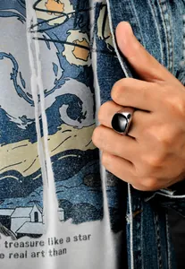 Close-up of a men's silver signet ring with a black square gemstone on a model's hand