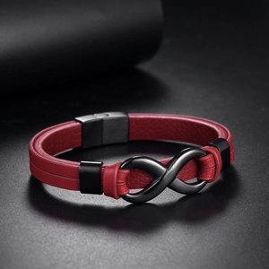 Dettaglio del bracciale in pelle rossa con simbolo infinito nero e finitura opaca