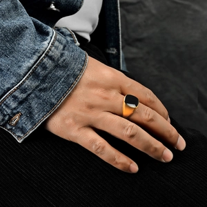 Men's vintage golden stainless steel signet ring with square black enamel on model's hand