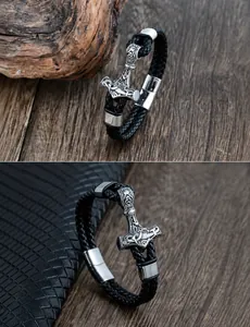 Macro detail of men's black braided leather bracelet with silver Thor's Hammer Mjölnir charm