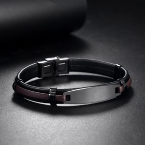 Macro shot of men's leather bracelet with a brushed gun-black metal plate and plug clasp