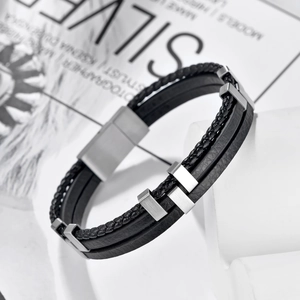Detailed close-up of multilayered black braided leather bracelet with magnetic steel clasp