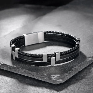 Men's triple-layer black braided leather bracelet with stainless steel accents on black stone