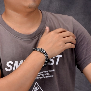 Detail of vintage punk chain bracelet on wrist showing antique finish and dragon carving