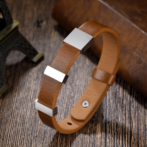Retro-Lederarmband in Braun mit Silbermetallplatten auf dunklem Holz im Vintage-Stil