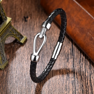 Close-up of black braided leather bracelet with silver horseshoe magnetic clasp on wood
