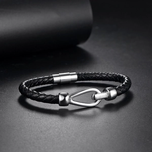 Close-up of black braided leather bracelet with horseshoe magnetic stainless steel clasp