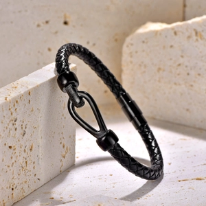 Detailed macro view of black braided leather bracelet with horseshoe U-shaped magnetic clasp