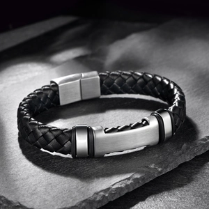 Braided black leather men's bracelet with brushed stainless steel clasp on rock