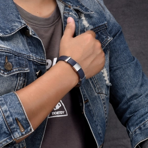 Nahaufnahme des blauen Lederarmbands für Herren mit silbernen Metallelementen am Handgelenk