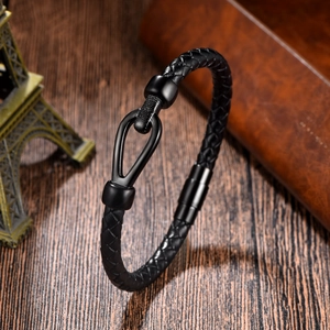 Macro detail of men's braided leather bracelet with black U-shaped magnetic metal clasp