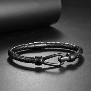 Detail of black braided leather men's bracelet with matte stainless steel buckle clasp