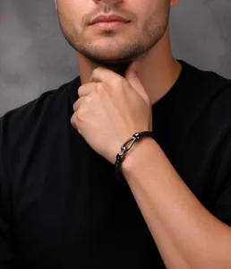 Detail of men's black braided leather bracelet with horseshoe buckle on a wrist