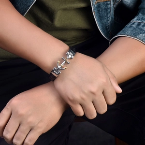 Detail eines Herren-Lederarmbands mit Anker-Anhänger in Silber- und Gold-Optik