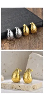 Détail de boucles d'oreilles dorées et argentées en forme de goutte et cœur