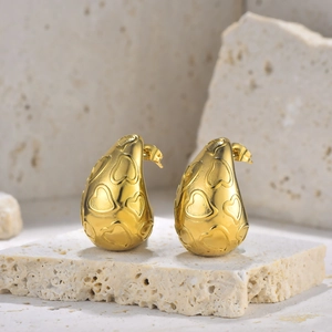 Boucles d'oreilles gouttes dorées avec motifs cœurs embossés sur fond en pierre naturelle