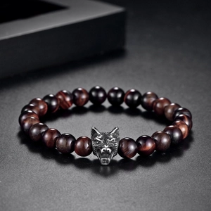 Detail view of tiger eye beads and engraved stainless steel wolf head charm on men's bracelet