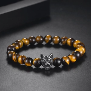 Detailed view of natural tiger eye beads and wolf head metal charm on beaded bracelet