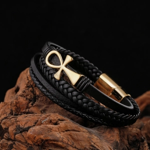 Détail macro du bracelet en cuir pour homme avec croix Ankh dorée et fermoir magnétique