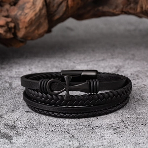 Détail macro d'un bracelet en cuir multicouche avec croix Ankh noire et fermoir aimanté