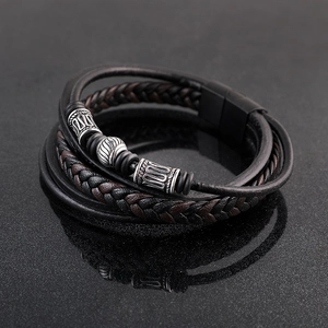 Close-up of multilayer leather bracelet featuring vintage metal beads and magnetic clasp
