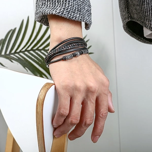 Detail of multilayer woven leather bracelet with vintage silver beads on male wrist