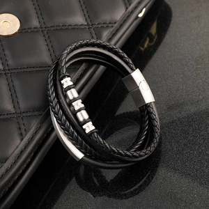 Detail of multi-layer black braided leather bracelet with magnetic stainless steel clasp