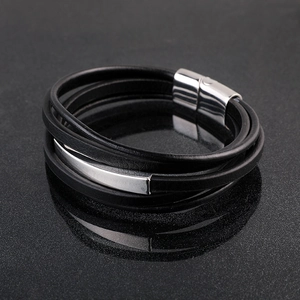 Primer plano detallado de una pulsera de cuero negro multicapa con cierre magnético de metal
