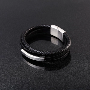 Vista macro de la pulsera de cuero trenzado negro multicapa con cierre magnético de metal plata