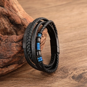 Detail view of multilayer black woven leather bracelet with matte blue metal magnetic clasp