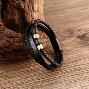 Detailed close-up of multilayer braided black leather bracelet with textured metal beads