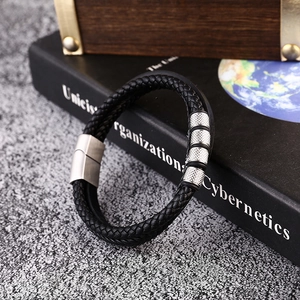 Close-up of men's multi-layer black braided leather bracelet with magnetic steel clasp