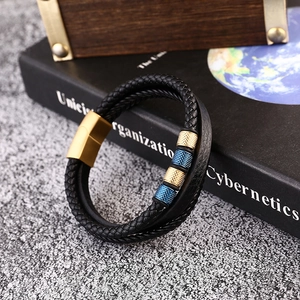 Detail of men's multilayer braided leather bracelet with blue and gold beads and magnetic clasp