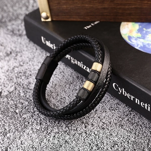 Detailed macro of men's multi-layer braided leather bracelet with gold textured beads