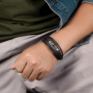 Detail of multilayer black leather bracelet with silver metal buckle and red stitching